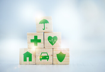 Protection is better than cure. Shot of wooden blocks with insurance related symbols on them.