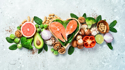 Ketogenic low carbs diet concept. Diet for the heart and blood vessels: nuts, salmon, avocado, spinach, mushrooms, berries. On a stone background. Top view. Copy space.
