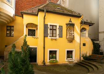 Picturesque old small house with side stairs and yellow facade in a historical courtyard in Bratislava, home of Austrian composer Johann Nepomuk Hummel