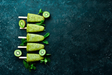 Kiwi Ice Cream Popsicle. Top view. On a stone background.