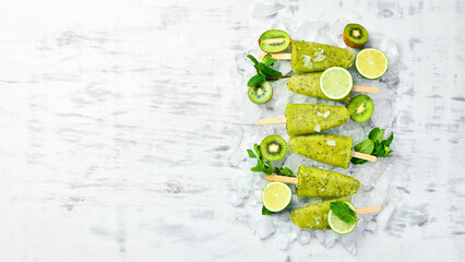 Homemade popsicle kiwi, lime and mint. fruit sorbet on a wooden background. Top view. On a white background.