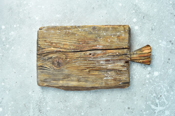 Old wooden kitchen board. Top view. On a stone background.