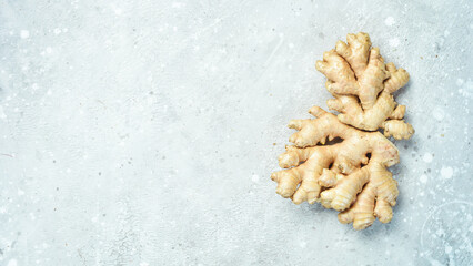 Fresh ginger root. Foods containing vitamin C. Free space for text on a stone background.