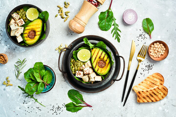 detox Buddha bowl with avocado, tofu cheese, flax, pumpkin seeds and spinach. The concept of dietary nutrition. On a stone background.