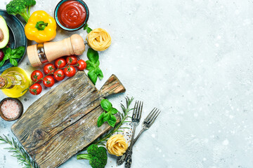 Food background. Vegetables, spices and pepper mill on a gray stone background. Top view. Free space for text.