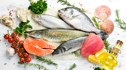 Seafood background: salmon, tuna, caviar, oysters, dorado fish and shellfish on a blue wooden background. Seafood. Flat lay.