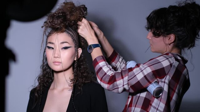 hairdresser at the photo shoot doing the hairstyle of the model