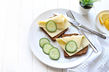 Fette di pane integrale con formaggio e verdure isolate su sfondo bianco. Antipasto di formaggio. Direttamente sopra.