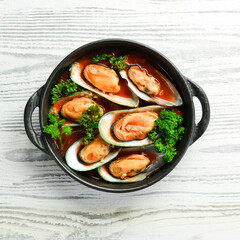 Large plate with mussels cooked in tomato sauce with garlic, parsley and lemon. Free space for your text.