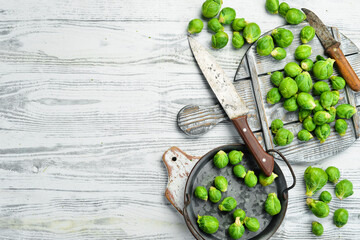 Vegetables. Fresh green brussels sprouts on a white wooden background. Rustic style. Top view.