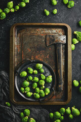 Fresh brussels sprouts in a metal tray on a black stone background. Healthy food. Top view.