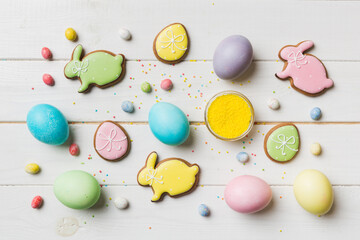 holiday preparation Multi colors Easter eggs with cookies on colored background . Pastel color Easter eggs. holiday concept with copy space