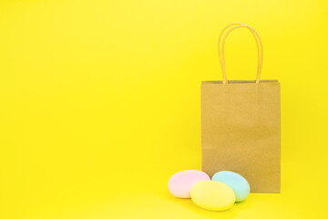 Paper bag on yellow background and easter eggs . Copy space. The concept of purchase, promotions, discounts, sale High quality photo