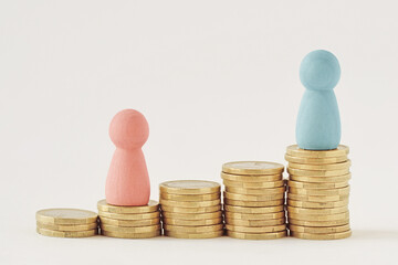 Pink and blue pawns on raising piles of coins - Gender pay gap concept - 495602257