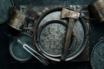 Metal kitchen utensils: plate, mug, kitchen utensils. Top view. Free copy space.