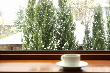Cup of tea stands on wooden windowsill
