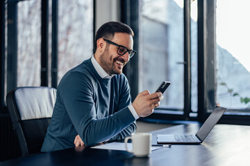 Smiling businessman, searching for something over the phone.