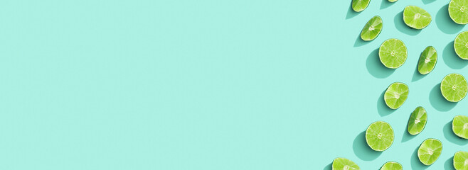 Citrus lime fruit as creative wide banner, slices of green lime with hard shadows at sunlight on...