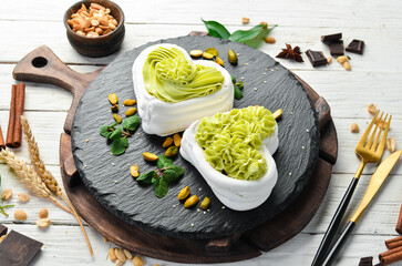 Pavlov's dessert. Bizet cakes with pistachio cream. Sweets. Top view. Rustic style.