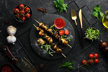 Obraz na płótnie Canvas Rapana skewers with vegetables on a black stone plate. Restaurant food. Seafood. Rustic style. Flat Lay.