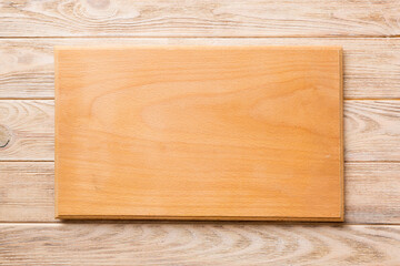 Top view of wooden cutting board on wooden background. Empty space for your design.=