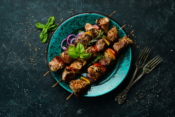 Kebabs - grilled meat skewers, shish kebab with vegetables on a plate. On a concrete old table. Top...