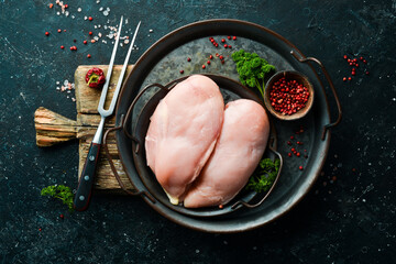 Chicken meat. Raw fresh chicken breast on black slate stone background. Top view. Raw meat.