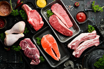 Set of fresh raw meat and fish in plastic boxes: veal, salmon steak, chicken, pork. Banner for the supermarket. On a dark background. Organic food.