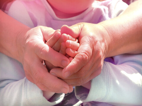 Grandmother and granddaughter holding hands together. Support, love and togetherness  people concept