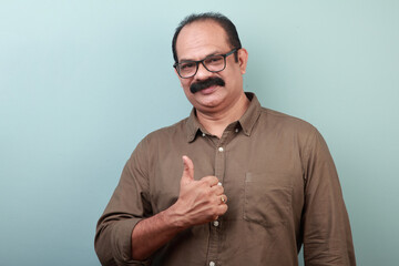 Portrait of a middle aged man of Indian ethnicity shows Ok gesture