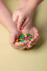 bright colorful sweets in children's palms