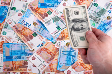 Russian rubles and a hand with a bundle of dollars