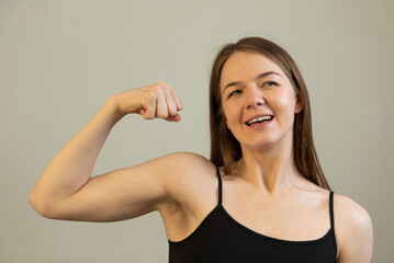 Fototapeta na wymiar strong happy woman shows her bicep muscle