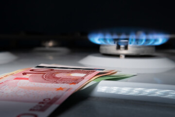 Concept of gas crisis.Euro banknotes on the background of a gas burner.Cash. High prices for...