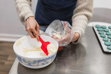 Pastry chef filling piping bag to decorate or fill sweets