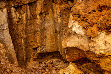 Textural sand, with  relief surface, multi-colored layers and different in size of granules, in outdoor sand career, after mining ore and sand for construction.