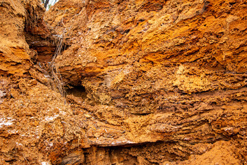 Textural sand, with  relief surface, multi-colored layers and different in size of granules, in outdoor sand career, after mining ore and sand for construction.