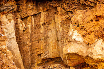 Textural sand, with  relief surface, multi-colored layers and different in size of granules, in outdoor sand career, after mining ore and sand for construction.