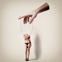 Young woman beautiful constrained with thread headless is a puppet in male hands, conceptual...