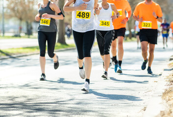 Marathon running race, people feet on road.