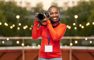 people, profession and photography concept - happy young woman or press photographer with digital...
