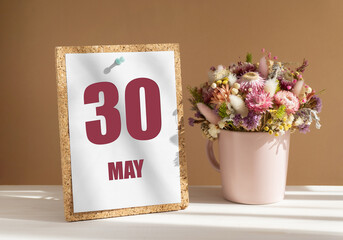 may 30. 30th day of month, calendar date.Bouquet of dead wood in pink mug on desktop.Cork board with calendar sheet on white-beige background. Concept of day of year, time planner, spring month