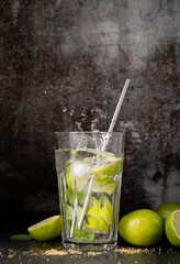 fresh summer caipirinha cocktail with splash on concrete background