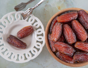 Bowl of dates fruit on colorful marble background, top view	