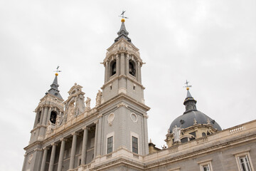 Fototapeta premium Main facade of Almudena Cathedral in Madrid, Spain. On the sides of the facade there are two bell towers. 