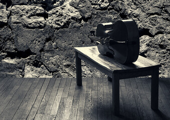 Music. Creative burnout. Cello lying on table. Wooden floor stone wall at background. Music craft...