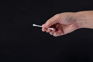 Hand picking cotton​ buds, black​ background​