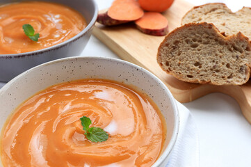 Homemade sweet potato soup served with sour cream in bowl on the table. vegetarian food. 