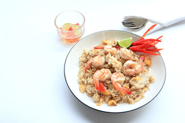 Shrimp fried rice. stir fried rice with shrimp decorate flowers from red chilly peppers, lime and fish sauce on table.Thai food style,Top view. 