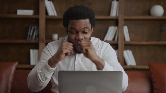 Young adult enteerpreneur recieving extremely good news in front of his laptop in office